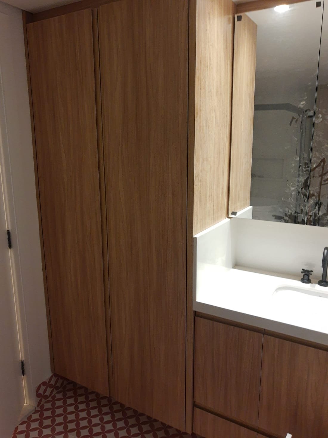 Lavabo planejado com gabinete amadeirado e espelho, projeto da Prado Marcenaria