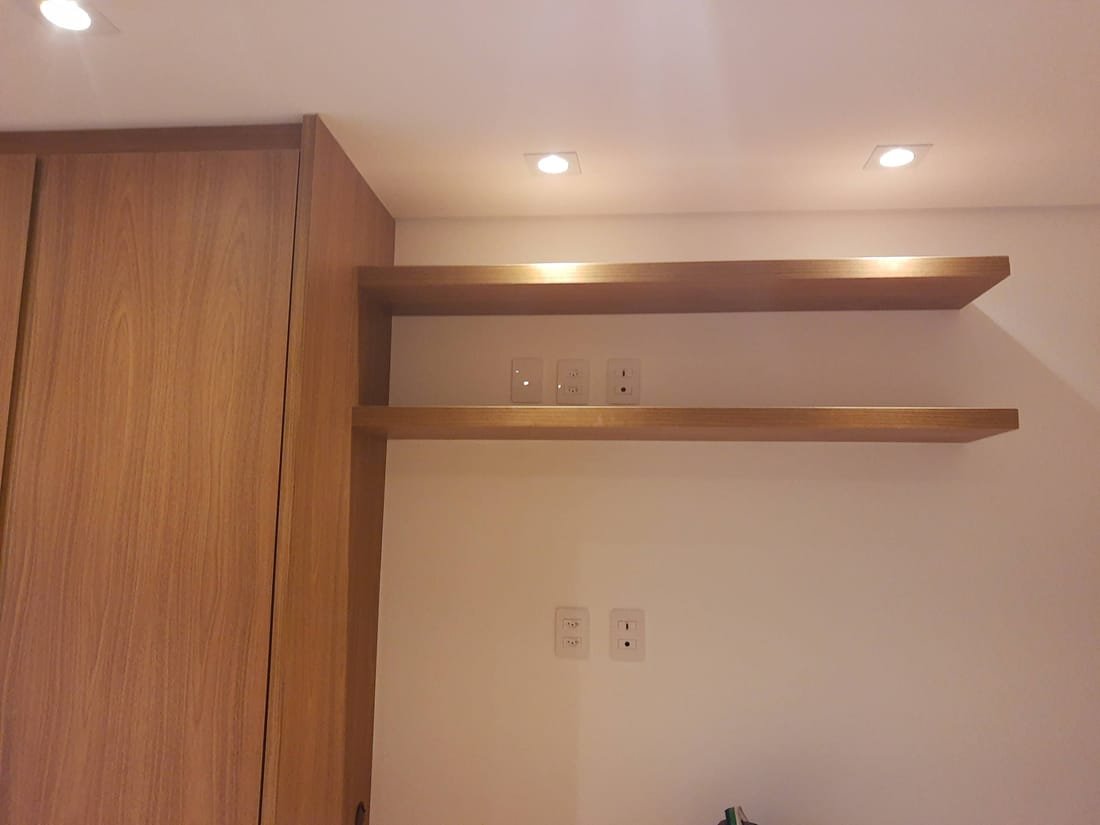 Closet planejado amadeirado com nichos e gavetas, projeto da Prado Marcenaria