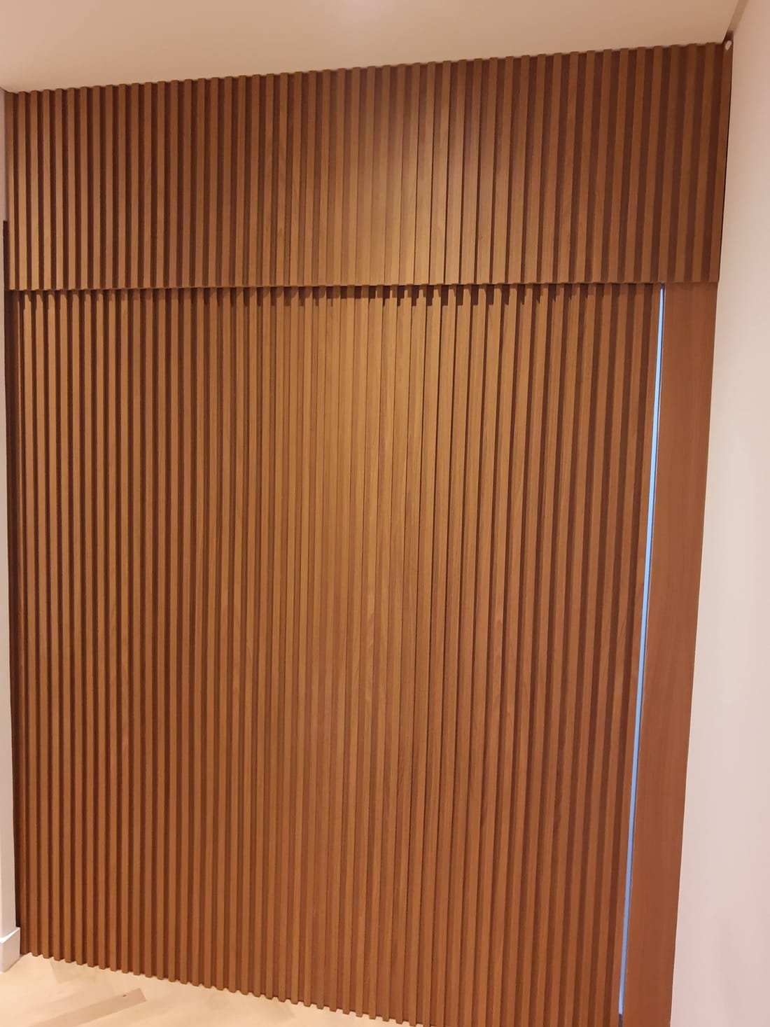 Painel ripado finalizado com acabamento em madeira, projeto da Prado Marcenaria
