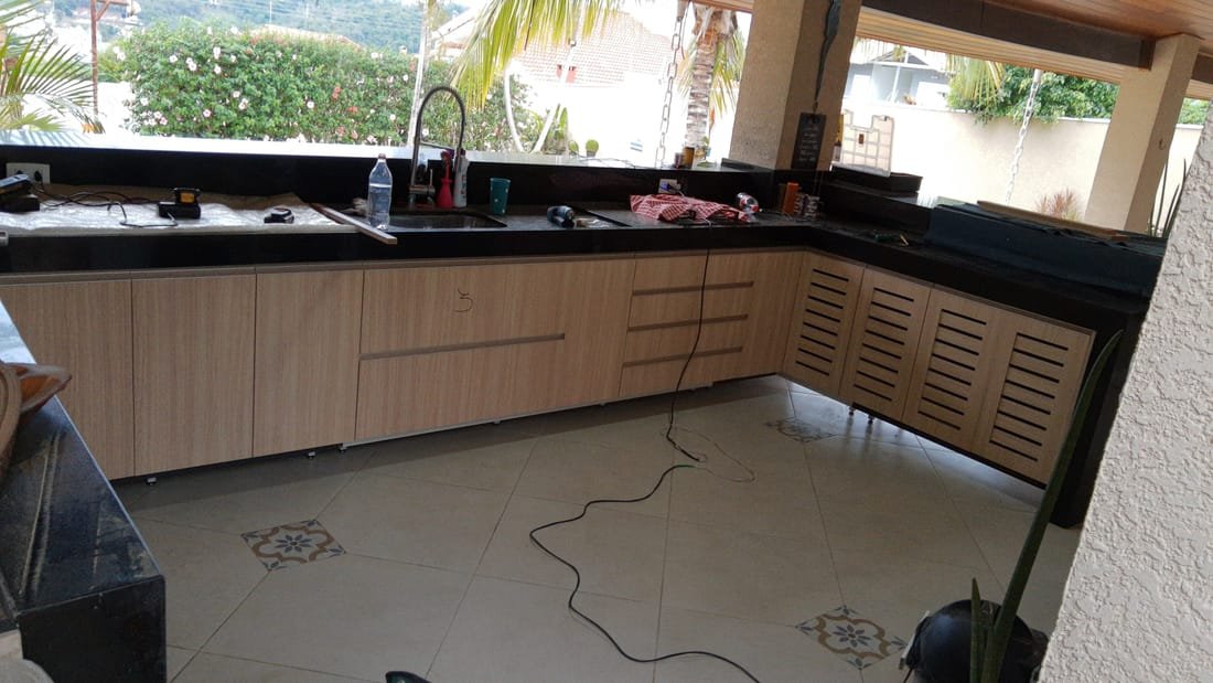 Espaço gourmet planejado com bancada aberta para a vista, projeto da Prado Marcenaria